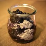 Cashew Chia Pudding in a small glass layered with wild blueberries