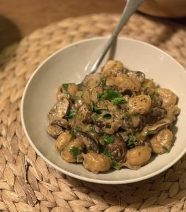 a plate with creamy gnocchi with mushrooms and parsley
