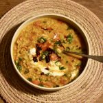 a plate of vegan red lentil dal on a wooden table