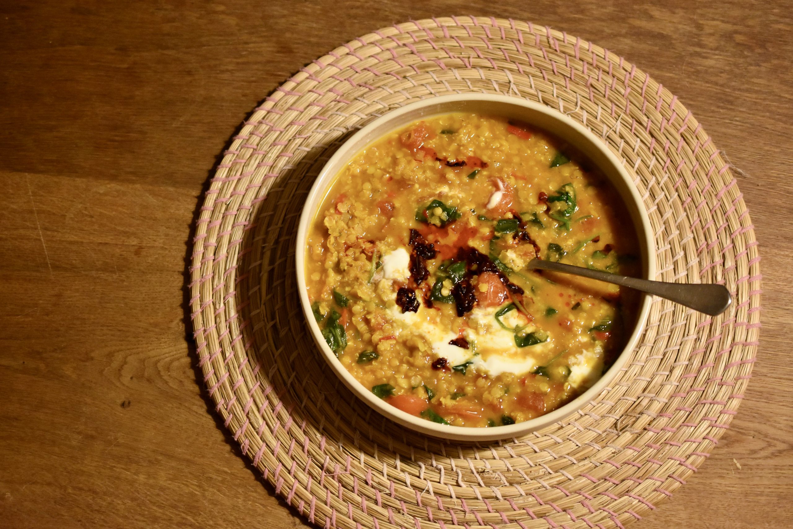 a plate of vegan red lentil dal on a wooden table