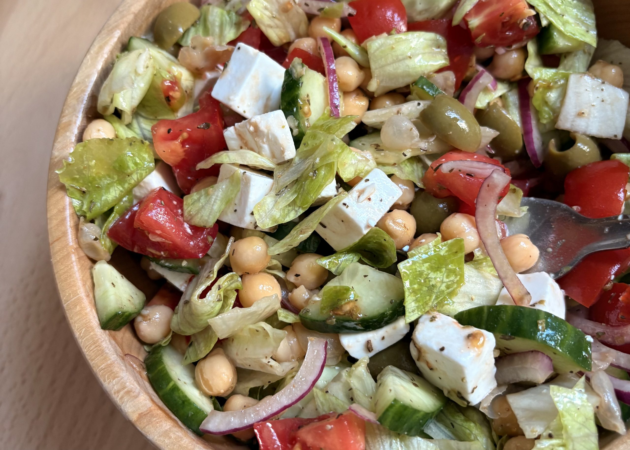 a vegan Greek chickpea salad in a wooden bowl