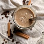 coffee smoothie in a glass with a glass straw and decorations