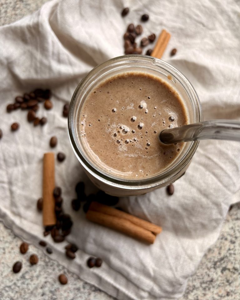 coffee smoothie in a glass with a glass straw and decorations